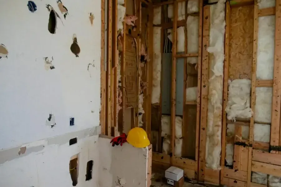 A wall opened to the studs with the insulation exposed for drying