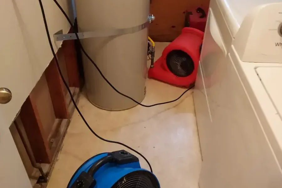 Air movers running in a laundry room with the wall opened behind the washer