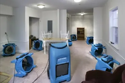 Air movers and dehumidifiers set up to dry out a room
